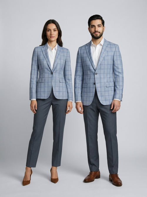 Dama y caballero con blazer azul cielo a cuadros sobre camisa blanca y pantalón gris, para resort.