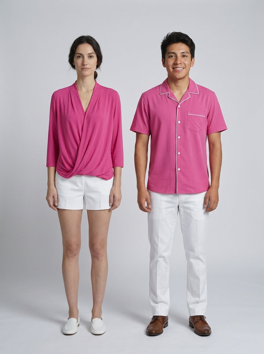 Dama con blusa rosa drapeada y bermuda blanca y caballero con camisa rosa y pantalón blanco para personal de alberca de resort.