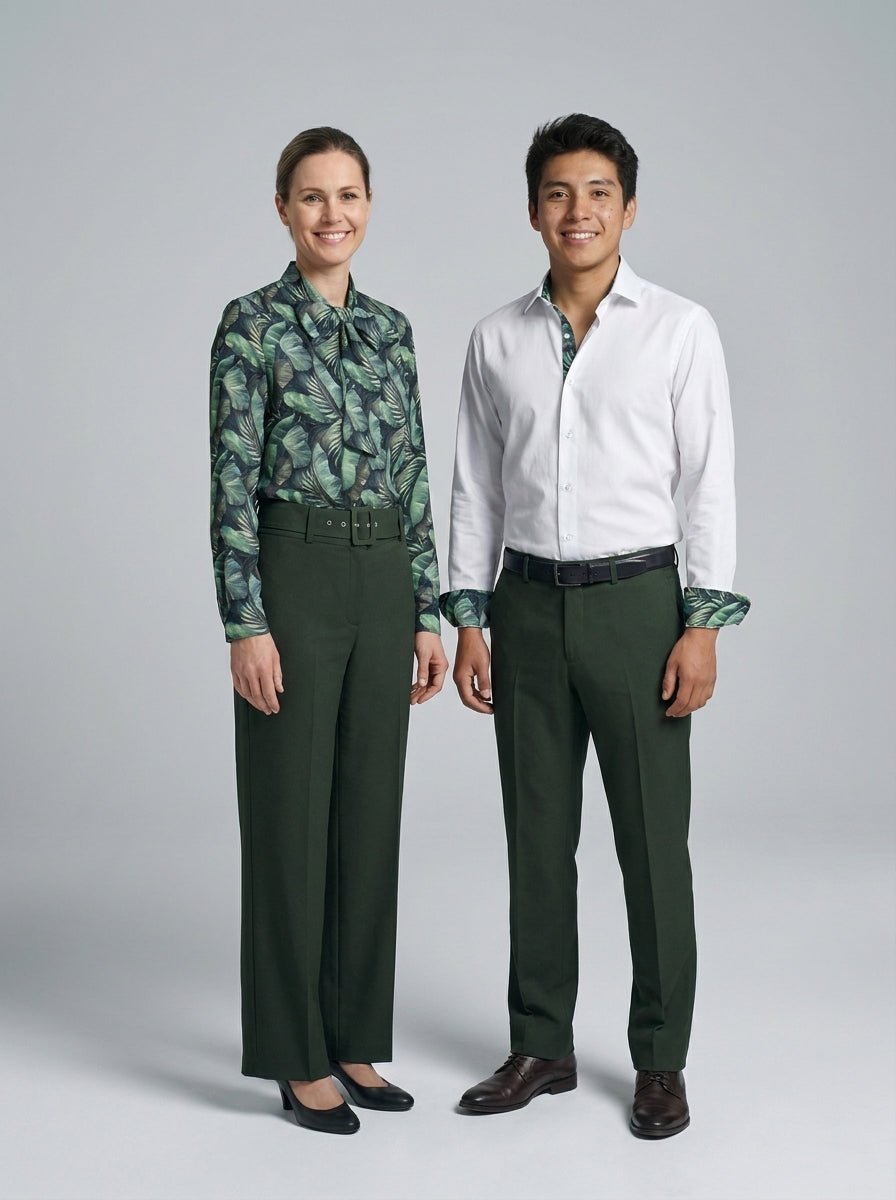 Dama con blusa de estampado tropical verde y caballero con camisa blanca, pantalón verde, para resort.