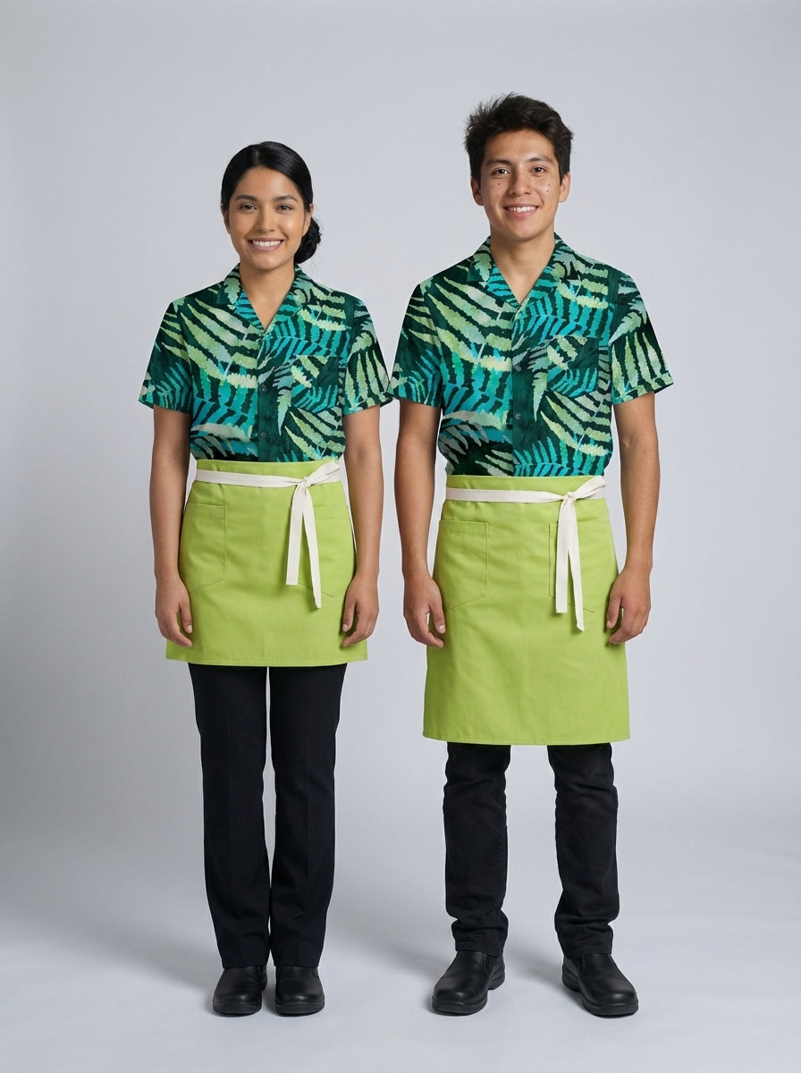 Dama y caballero con camisa de estampado tropical verde y mandil verde lima para personal de restaurante.