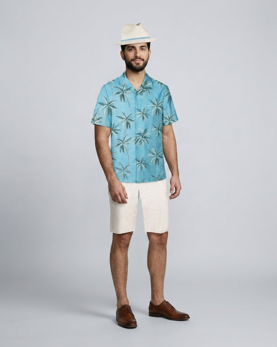 Caballero con camisa tropical de palmeras turquesa y bermuda crema, para personal de resort.