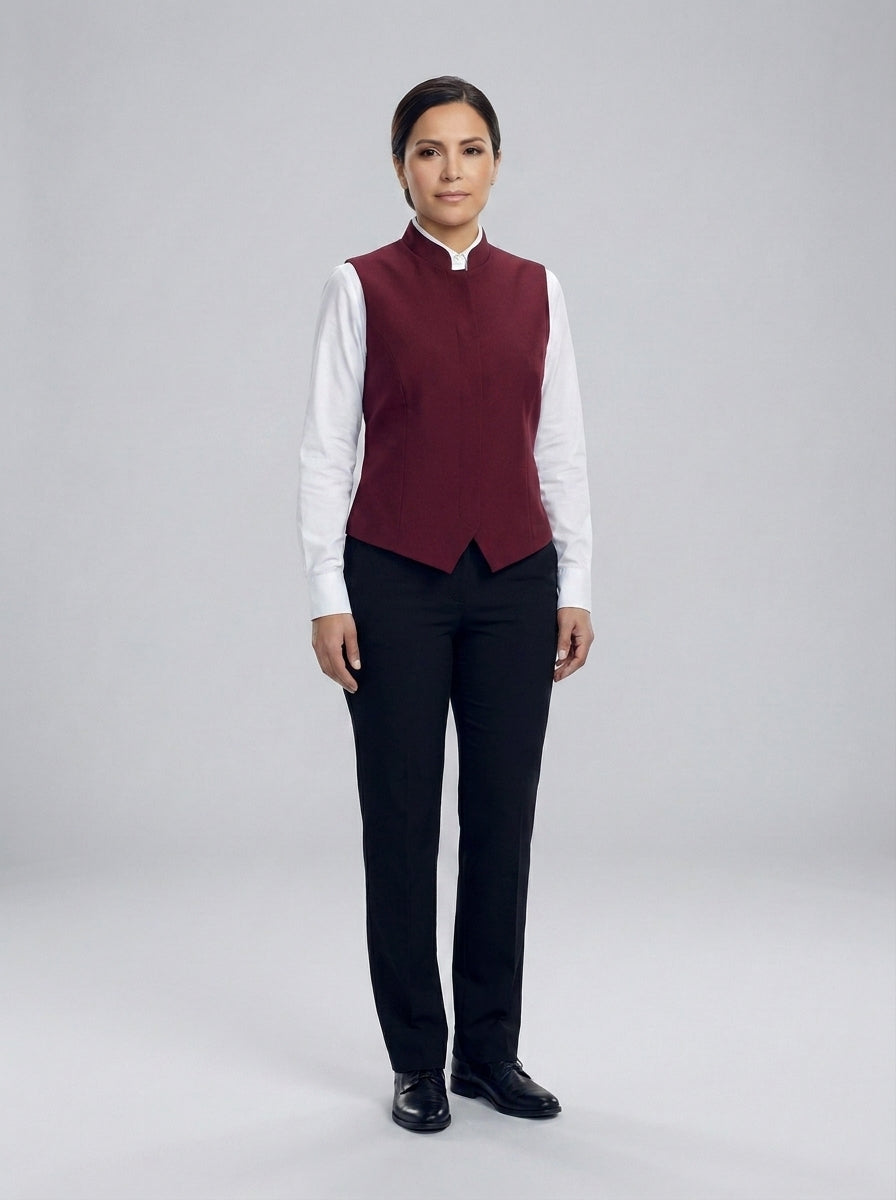 Dama con chaleco vino de cuello mao alto sobre camisa blanca y pantalón negro para anfitriona de restaurante.
