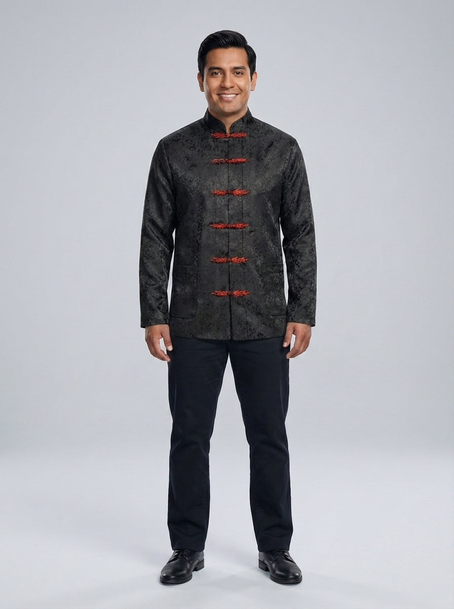 Caballero con chaqueta negra de jacquard, cuello mao y presillas rojas estilo asiático sobre pantalón negro para restaurante.