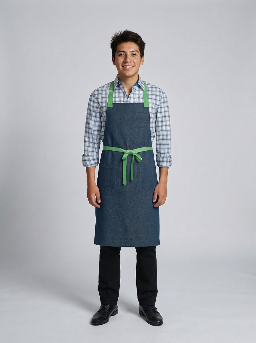 Mandil tipo pechero en tela denim azul con tirantes y cinturón en verde para mesero de restaurante.