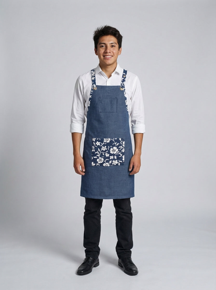 Mandil tipo pechero denim azul con bolsillo y tirantes en tela floral azul y blanco para mesero y barista de restaurante boutique.